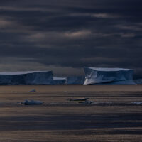 Eine Gruppe sehr großer Tafeleisberge im Dämmerlicht der goldenen Stunde kurz vor Sonnenaufgang auf der Iceberg Alley im Southern Ocean.